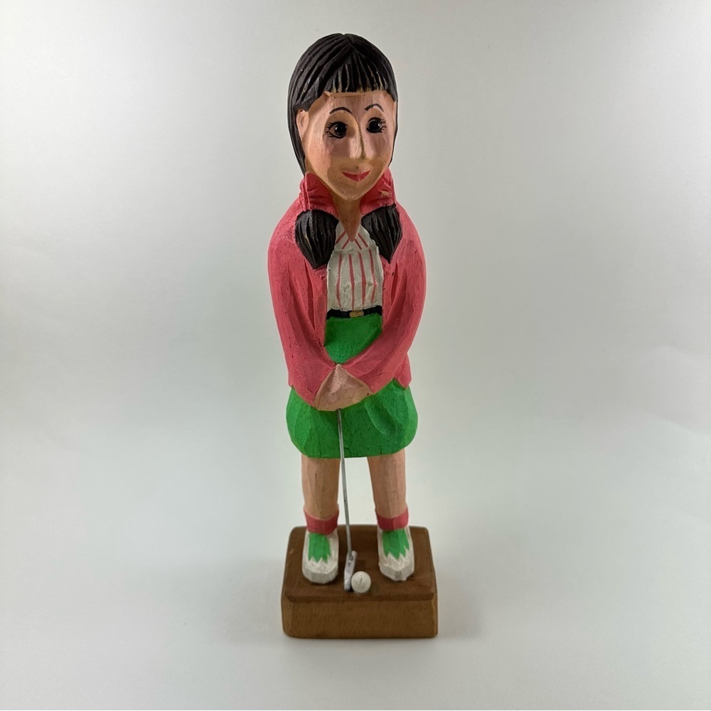 Vintage hand-carved wooden figurine of a female golf player